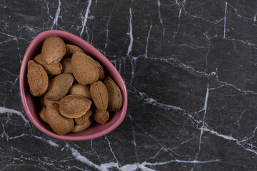 Bowl full of almonds , on the marble background