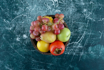 Variety of tasty fruits in wooden bucket