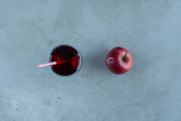 Red tasty juice with fresh apple and straw