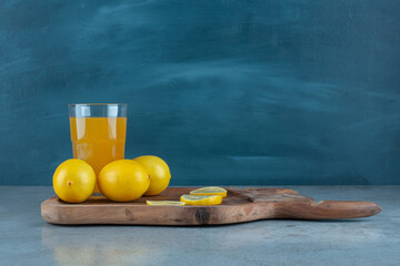 A glass cup of orange juice with fresh lemons