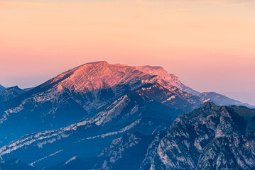 Plakat Beautiful crimson light at sunrise over the mountain peak.