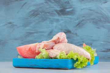 Sliced tomatoes and meat on the lettuce , on the board, on the white background