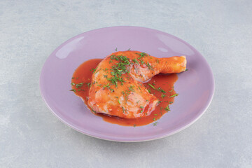 Delectable ketchup with drumstick on the plate, on the white background