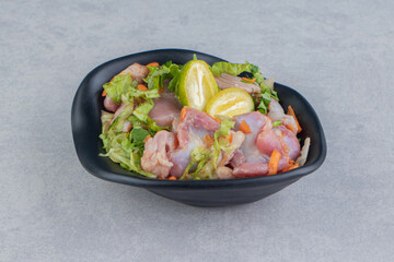 Delicious kumquat and marinated chicken pieces in the bowl, on the white background