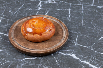 Sweet bun on the board, on the marble background