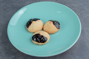 A blue plate of round cookies with chocolate