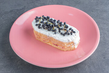 A piece of chocolate creamy cake on a pink plate