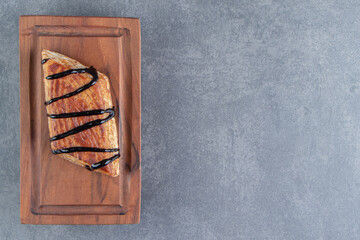 Delicious sweet triangle pastry on a wooden board
