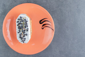 A piece of creamy cake with chocolate on an orange plate