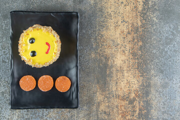 Slice of homemade cake with yellow glaze on dark plate