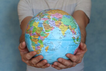 The globe. A man holds a globe in his hands. Close-up. Copyspace