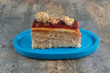 Slice of caramel cake on blue plate