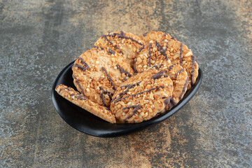 A black bowl with delicious crispy cookies