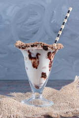 Vertical photo glass of chocolate milk shake on sack