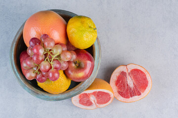 Bowl full of seasonal fruit and half cut grapefruit