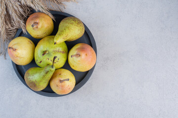 close up photo Pile of colorful pears on black plate