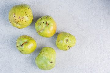 Pile of green organic pears on grey background