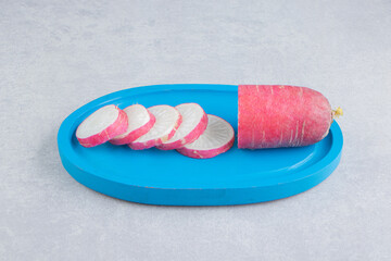 A display of radish on the tray, on the marble background