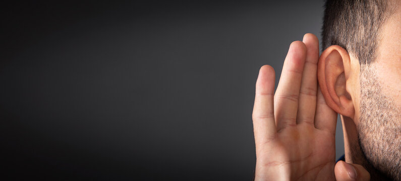 Caucasian man hold hand near ear. Trying to hear a gossip