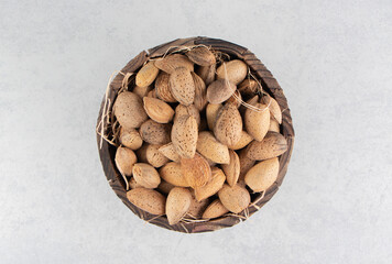A pile of almonds in the bucket, on the marble background