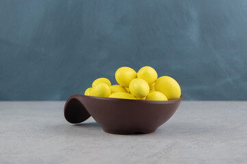 Yellow gums in the bowl on the marble background