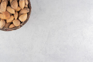 A full bucket of almonds in the bucket, on the marble background