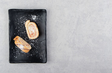 Delicious roll cake on the board, on the marble background