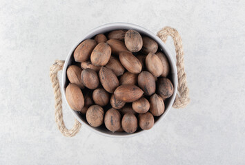 A full bucket of tasty nuts , on the marble background