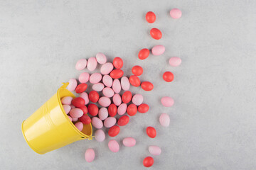 Gums spill out of a bucket, on the marble background
