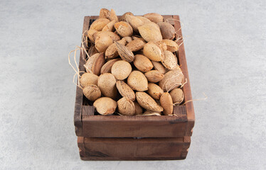 The box is full of almonds on the marble background