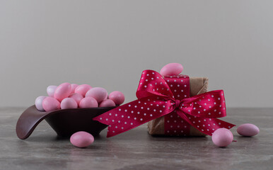 Gift box and a bowl of chewing gum , on the marble background