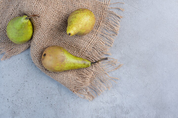 Juicy pears on a piece of cloth on marble background