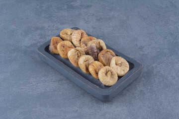 Tasty dried fruit on the tray, on the marble background