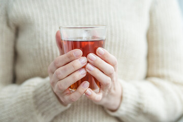 Cup of hot tea in female hands close-up. Background. Beverage concept, lifestyle, autumn and winter.