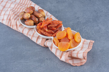 Toothsome dried fruit on the towel, on the marble background