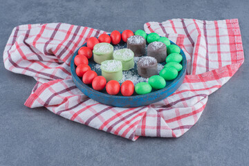 Gums and biscuit on the board , on the marble background