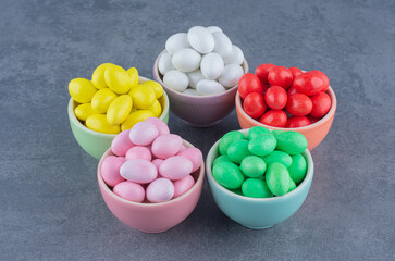 Five bowls of gum, on the marble background