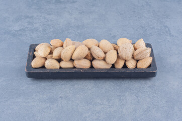 A tray of tasty almonds , on the marble background