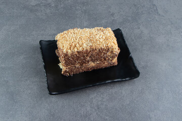 A piece of delicious Napoleon cake on a dark board