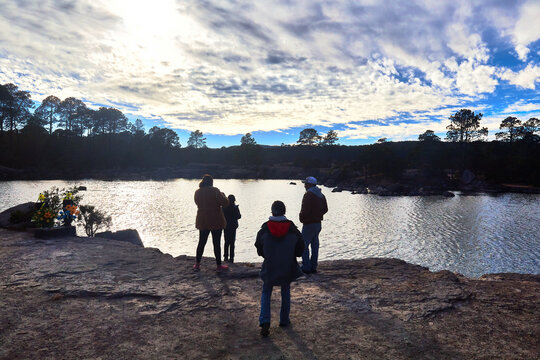 family in front of a lake with cloud sky and sun behind of the clouds in mexiquillo durango 