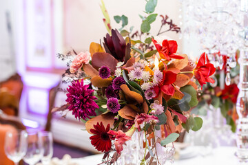 Festive table setting with basket of autumn flowers, candle