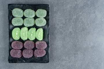 Fruit jelly sweet colorful candies on a dark plate