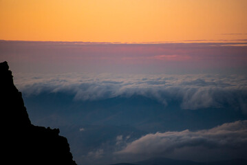 Panoramic view form mountains peak on the bright sunset  with clouds.