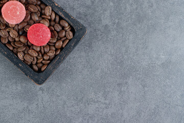 Fruit jelly candies with coffee beans on a dark board