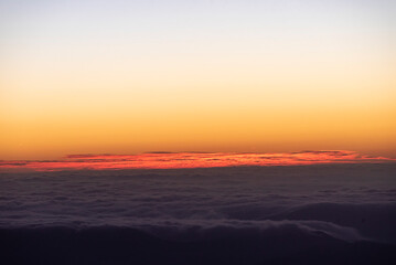 Panoramic view form mountains peak on the bright sunset  with clouds.