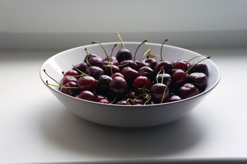 Large white glass plate full of cherries