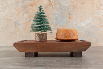 Sweet cupcake with candy and pine tree on wooden board