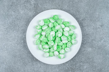 Hard green candies on white plate
