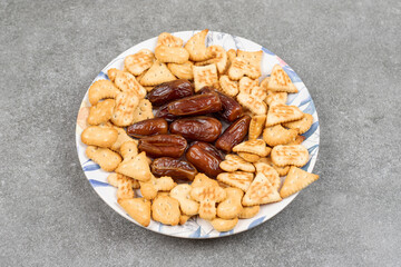 Crackers and organic dates on colorful plate