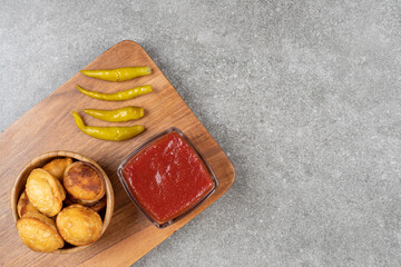 Fried dumplings and pickled pepper on wooden board
